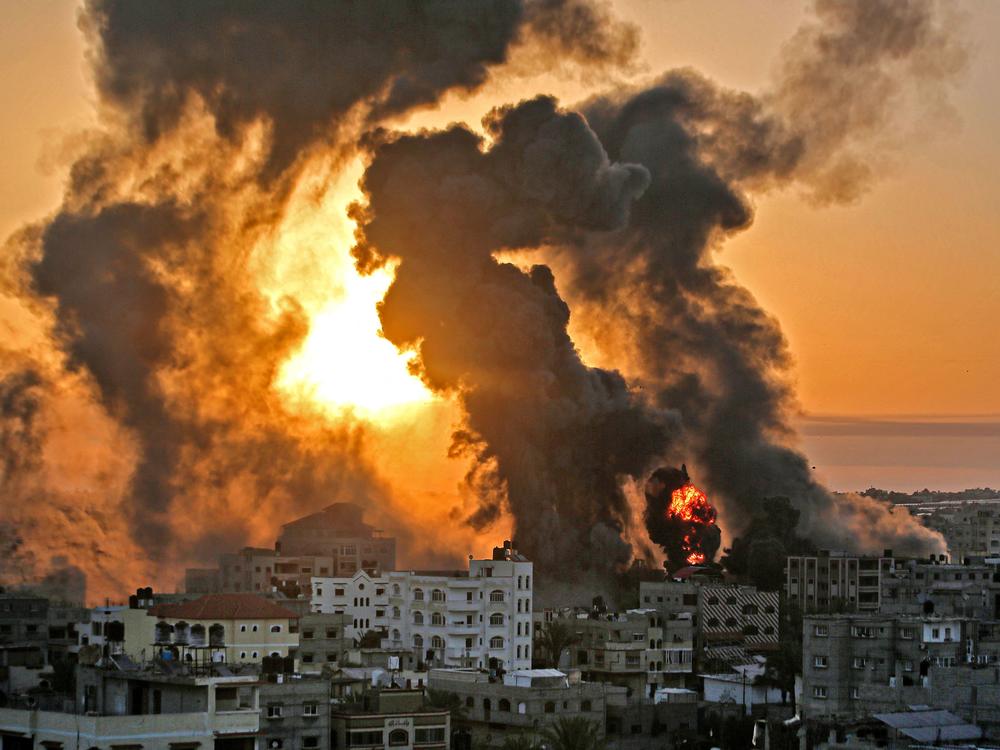 A fire rages at sunrise in the city of Khan Yunis following an Israeli airstrike in the southern Gaza Strip early on May 12.