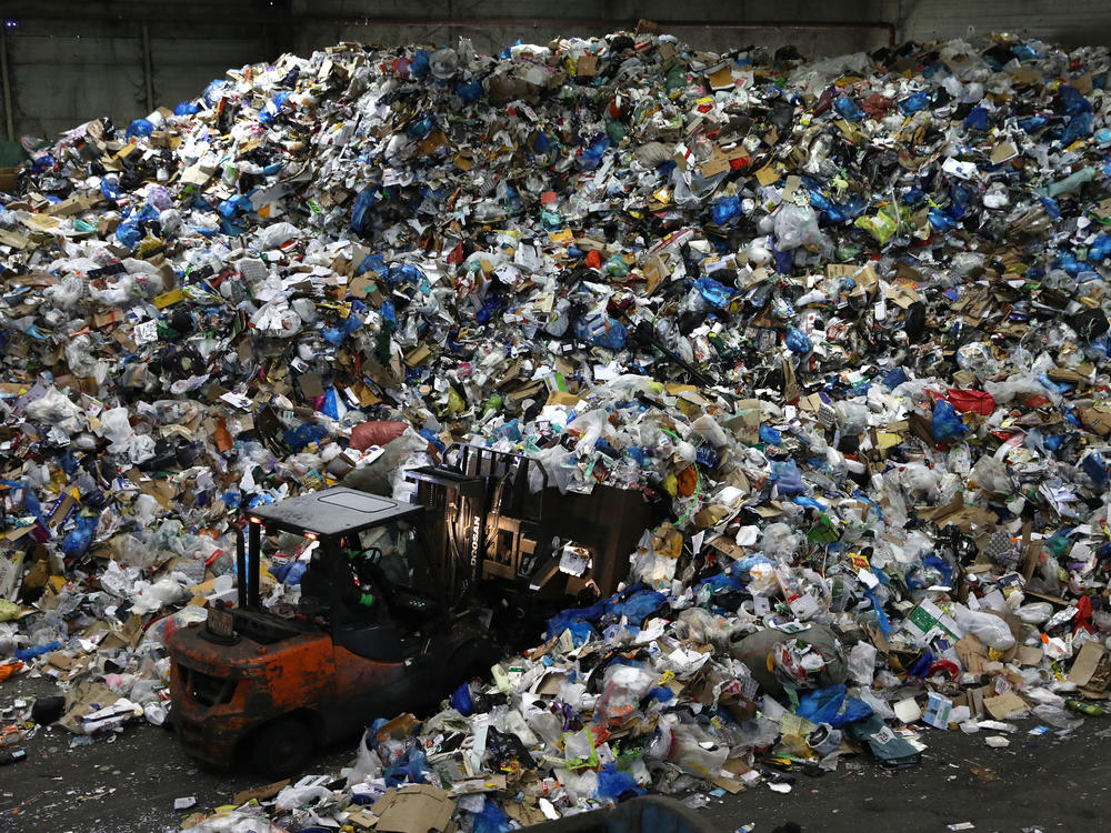 A worker operates a forklift to move household waste at a facility that stores recyclable materials in Seoul, South Korea. In 2019, more than 130 million metric tons of single-use plastics were thrown away, according to a new report.