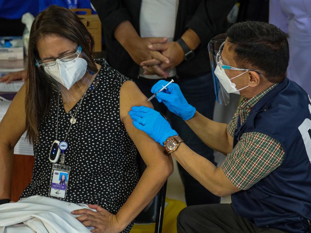 Philippines Health Secretary Francisco Duque III administers the China-made Sinovac COVID-19 vaccine to Eileen Aniceto, a doctor at the Lung Center of the Philippines.