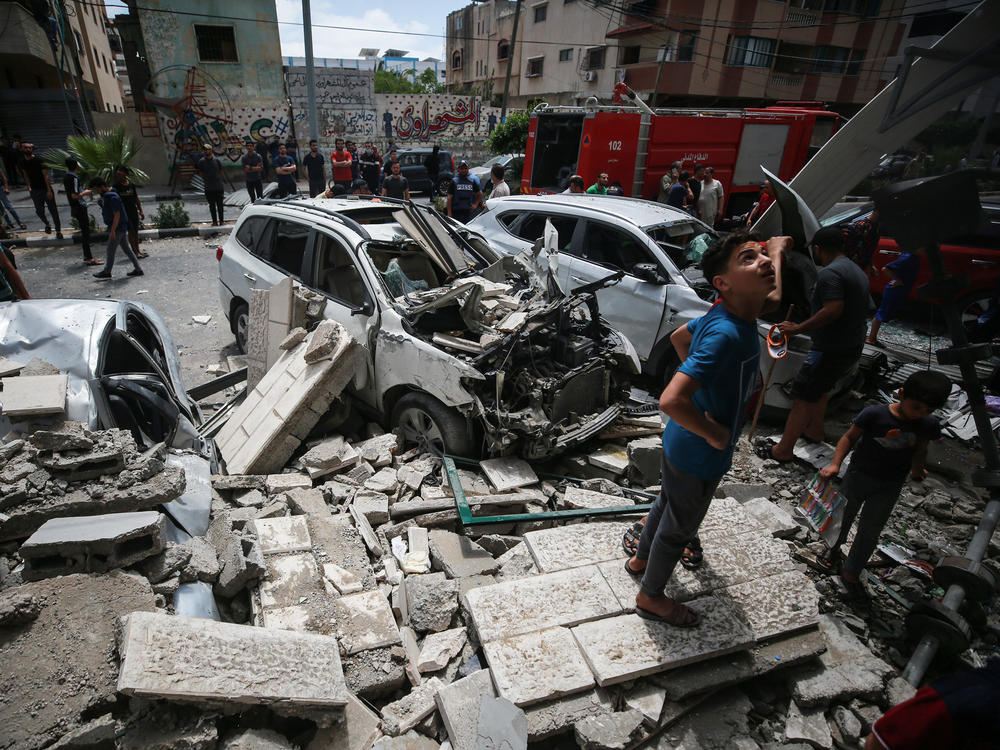Young Palestinians inspect the damage an Israeli attack inflicted on houses in the Sabra neighborhood of Gaza City. A man who lives in the middle of the Gaza Strip says his family is traumatized by the violence.