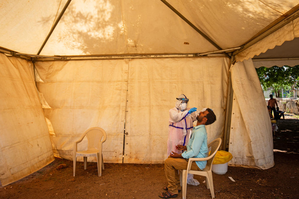 A medic performs an oral swab test for the coronavirus this week in Mysore, Karnataka, India. India's prolonged and debilitating wave of infections has reached deep into rural India, where the true extent of devastation may never be known because of a lack of widespread testing or reliable data.