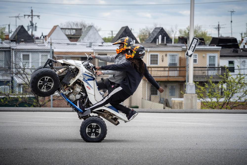 Instructor Mike Chester wheelies an ATV in tandem with Harrell.