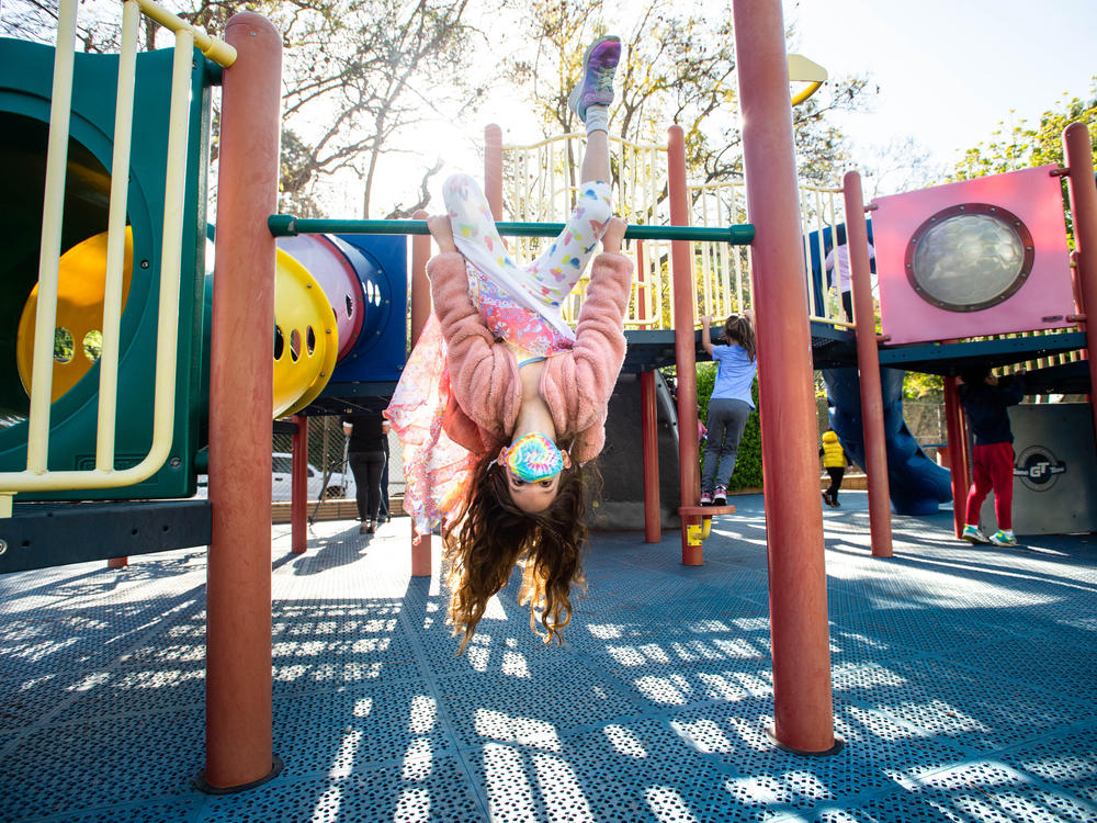A student wears a mask while swinging around with her kindergarten class this month at Kenter Canyon School in Los Angeles.