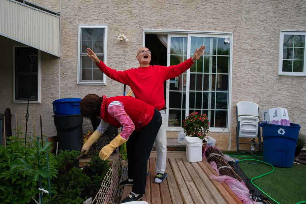 The couple have a small garden in their backyard where they have planted their favorite flowers. Here, as Lai fertilizes the plants, Chan sings a love song for her.