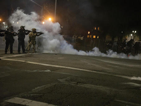 Federal law enforcement officers fire impact munitions and tear gas at protesters demonstrating against racism and police violence in front of the Mark O. Hatfield federal courthouse in Portland, Ore., on July 16, 2020. Through the end of 2020, the majority of last year's federal civil disorder charges were filed in Oregon.