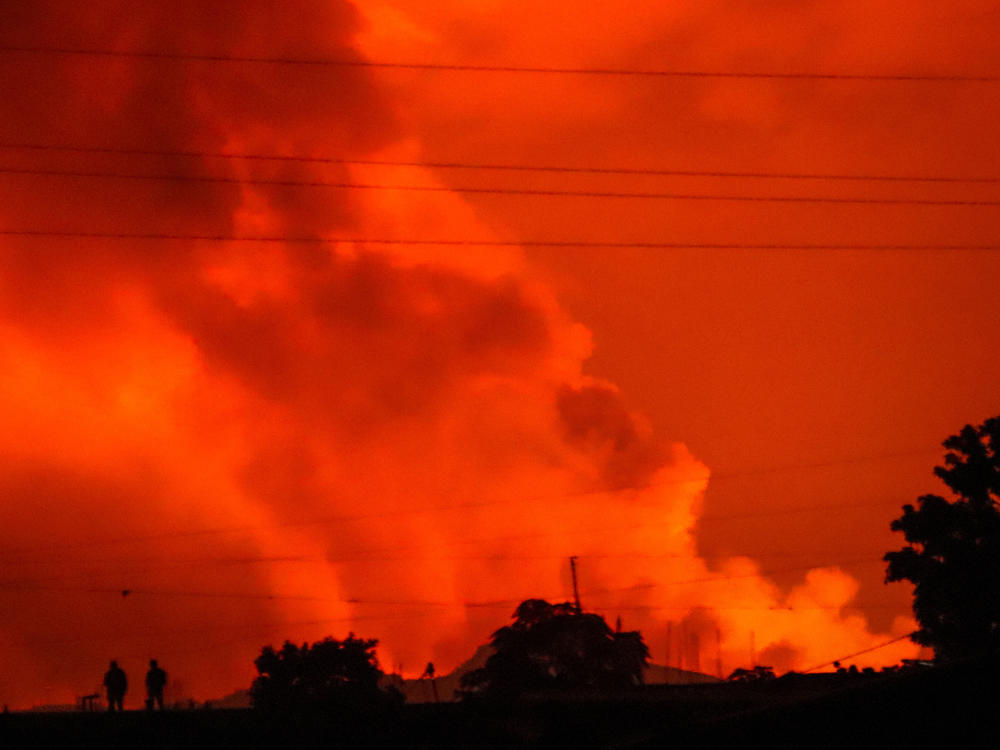 Two people are seen silhouetted against a night sky turned red by the eruption of Congo's Mount Nyiragongo on Saturday.