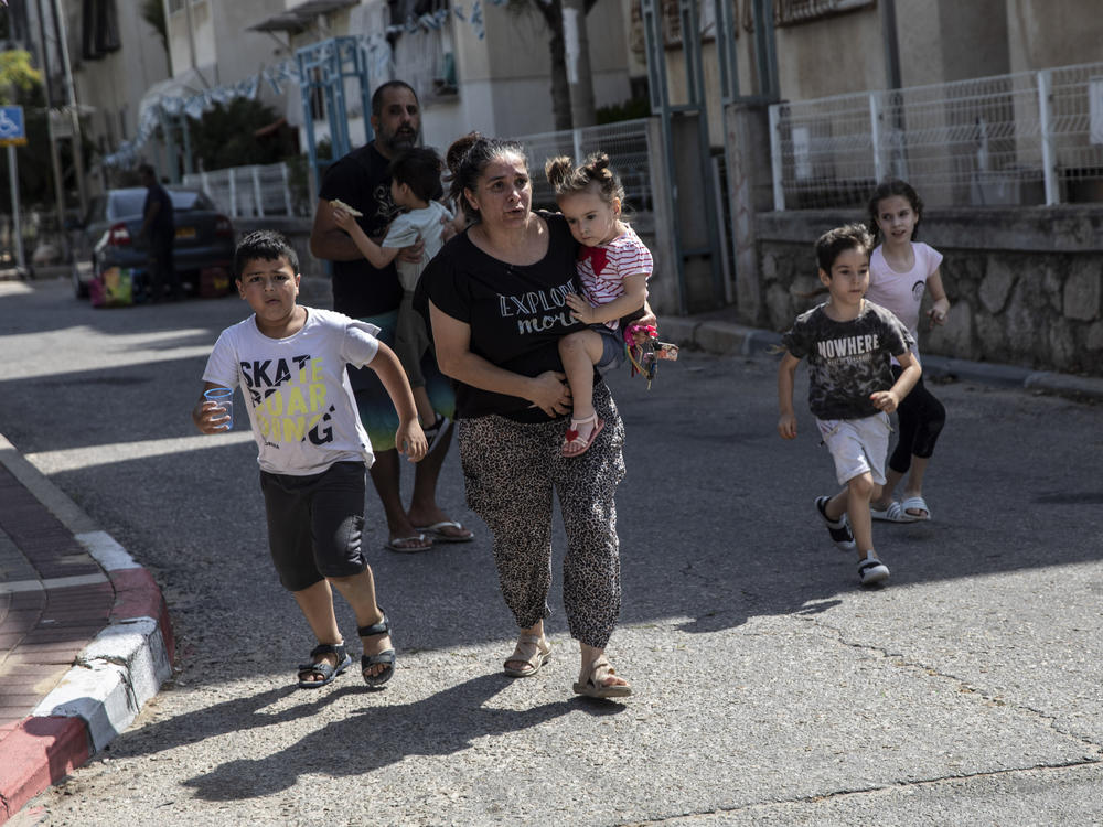 Israeli mother Lia Tal rushes with her children and partner to take shelter as a siren sounds a warning of incoming rockets fired from the Gaza Strip in Ashdod, Israel, on May 20.