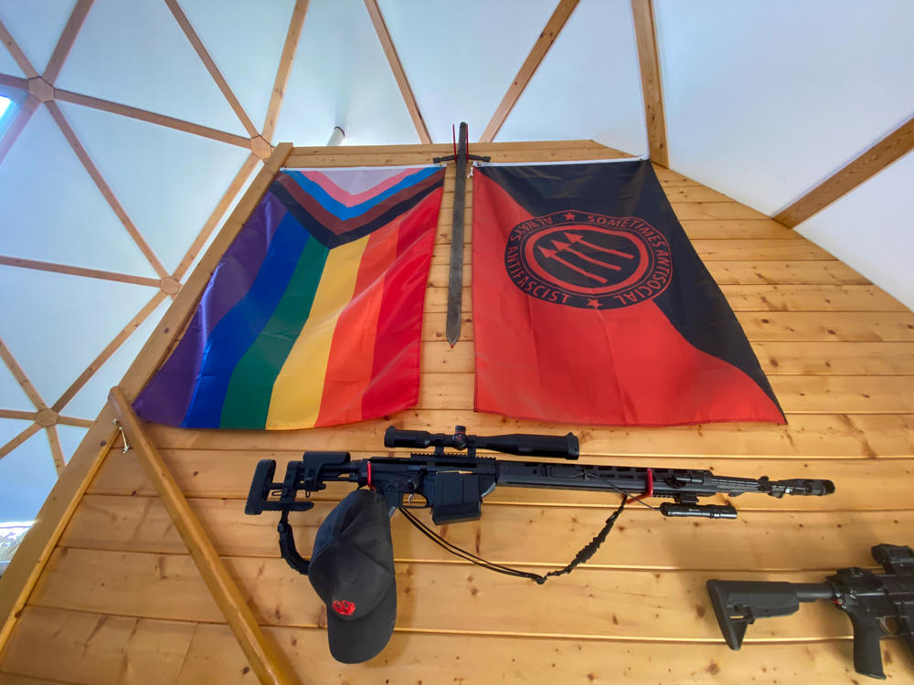 Various guns and flags adorn the wall leading up to the ranch house's second floor.
