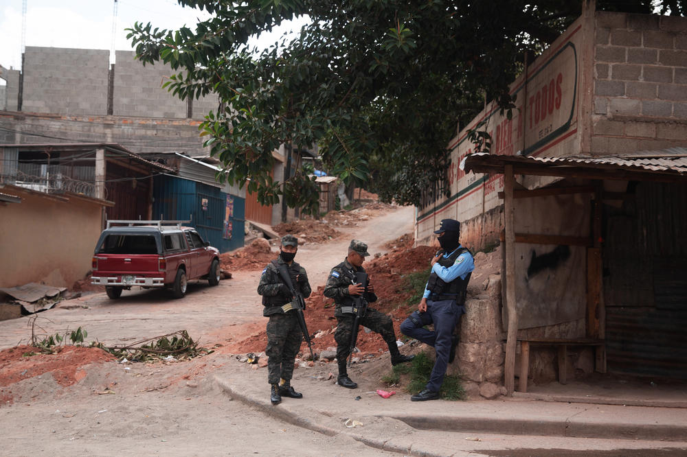 Members of the military police and civilian police stand on a corner in Tegucigalpa.