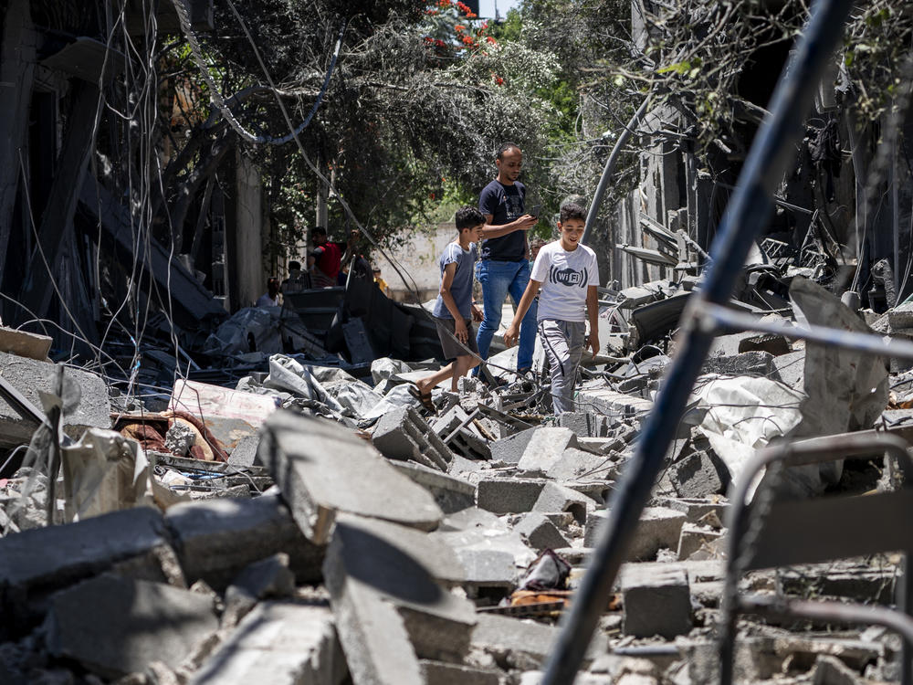 Children walk among the rubble of a building that was destroyed by an airstrike in Magazzi, the Gaza Strip.