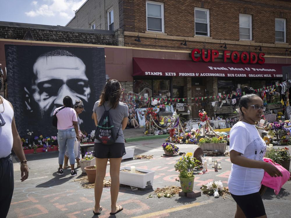 People walk through George Floyd Square on the anniversary of George Floyd's death in Minneapolis, Minn.