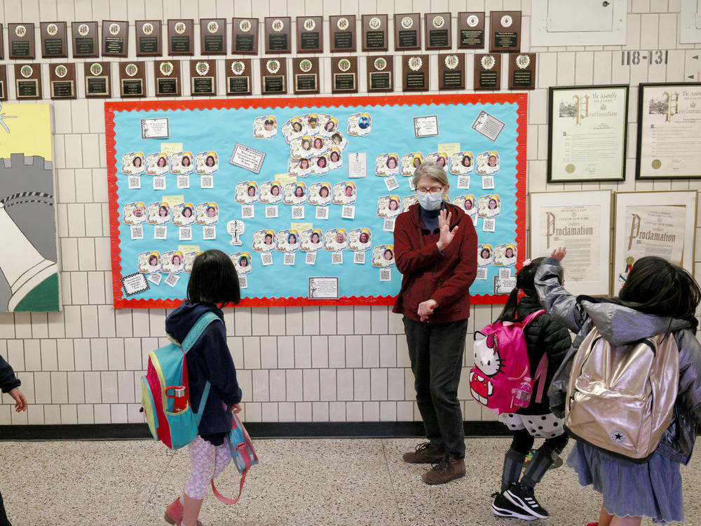 Students wave goodbye during dismissal at Yung Wing School P.S. 124 on March 25, 2021 in New York City.