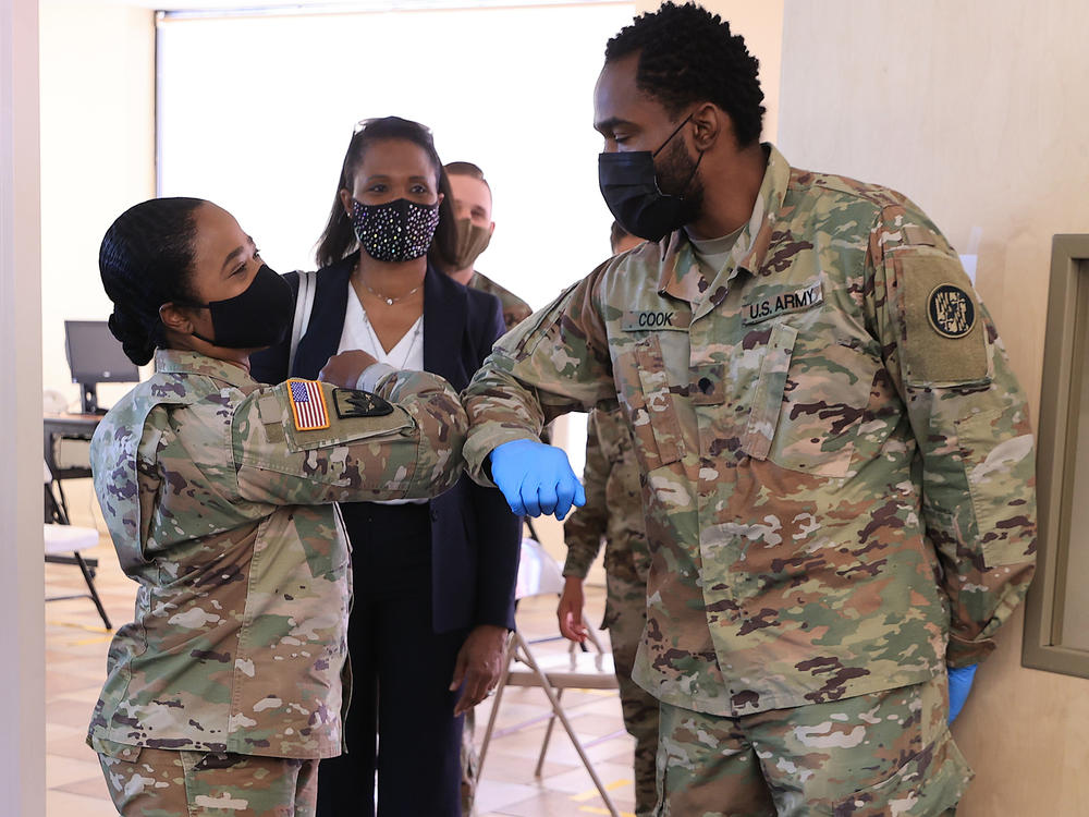 Nearly 130 million U.S. adults have completed their vaccine regimens, the CDC says, with another 70 million vaccine doses currently in the distribution pipeline. Here, Maryland National Guard Brig. Gen. Janeen Birckhead greets soldiers last week at a mobile vaccine clinic in Wheaton, Md.