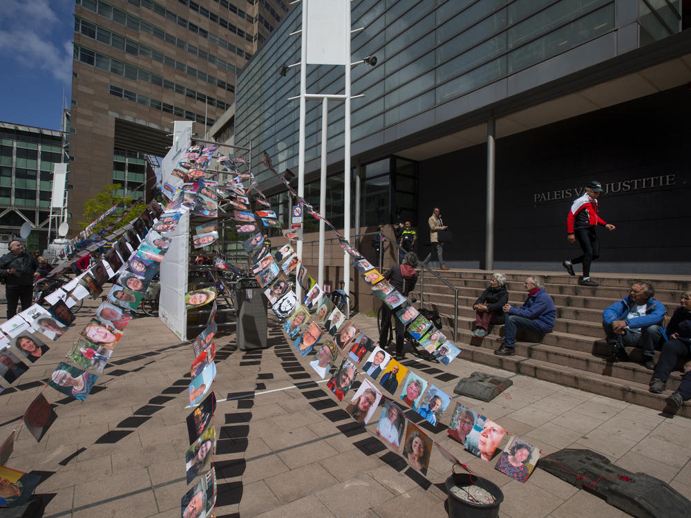 Pictures of plaintiffs fly outside the court in The Hague, Netherlands, before Wednesday's ruling ordering Royal Dutch Shell to rein in its carbon emissions. Thousands of citizens joined the suit charging that Shell's fossil fuel investments endanger lives.