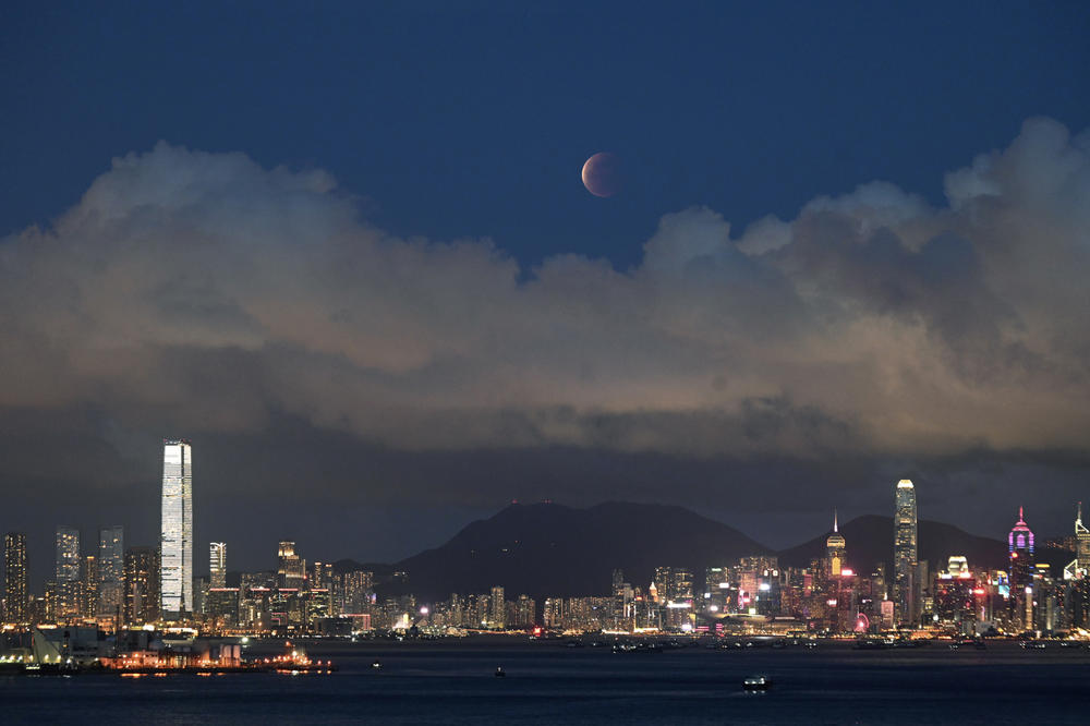The moon rises over Victoria Harbour in Hong Kong on Wednesday.