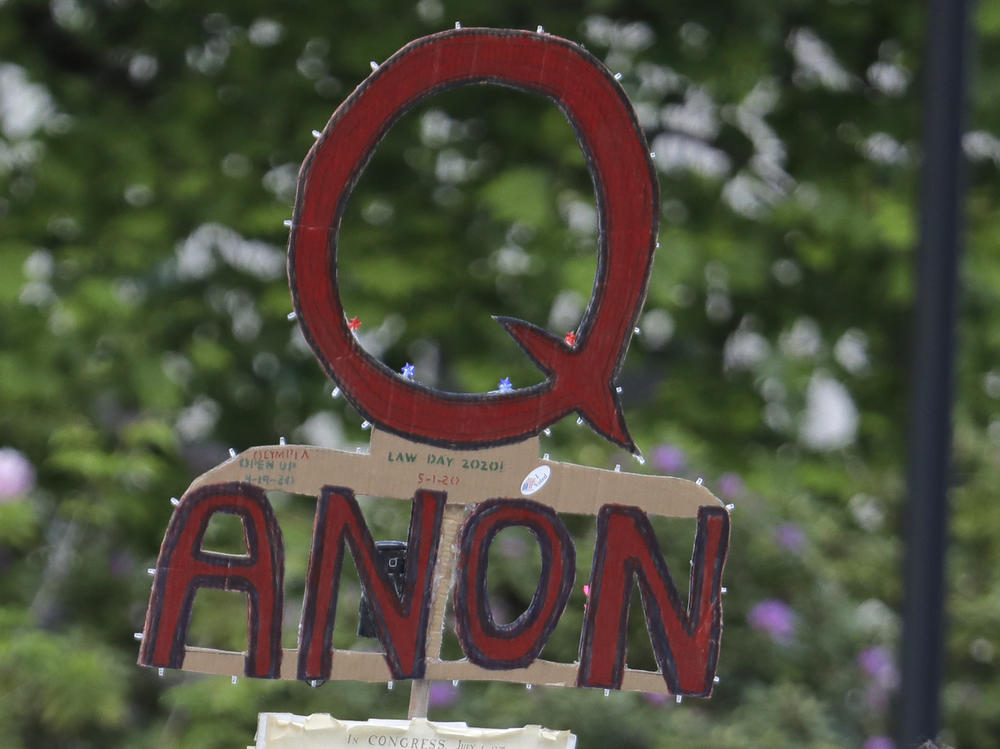 A person carries a sign supporting QAnon during a May 2020 protest rally in Olympia, Wash.