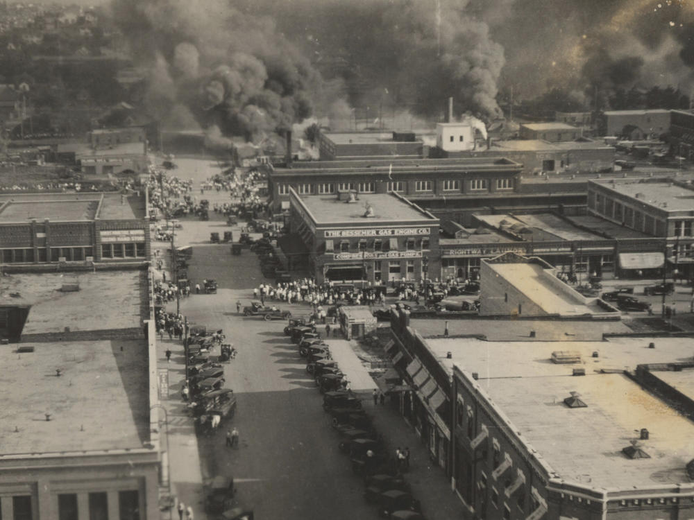 This archival photo shows crowds of people watching fires during the June 1, 1921, Tulsa Race Massacre.