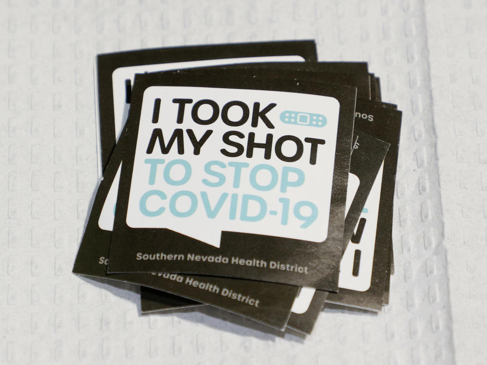 Stickers are stacked up for people receiving vaccinations at a pop-up COVID-19 vaccination clinic in Las Vegas on May 21. As countries open their doors to travelers again, there is confusion about how people will prove their vaccination status.