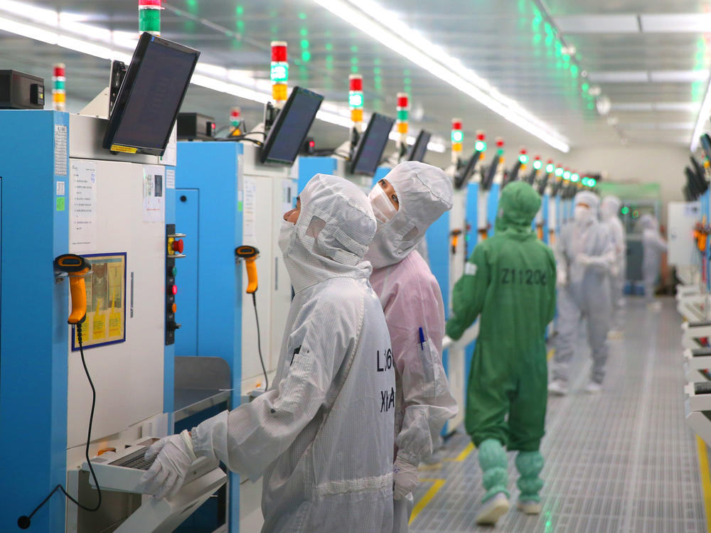 The Senate is expected to approve incentives for U.S. companies to compete with China on technology. Here, employees work this week at a Chinese factory producing silicon wafers.