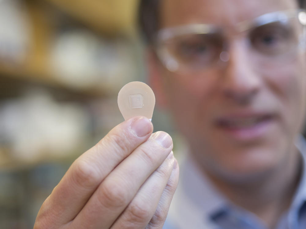 Mark Prausnitz, Georgia Tech Regents' professor in the School of Chemical and Biomolecular Engineering, holds a vaccine patch containing microneedles that dissolve into the skin.