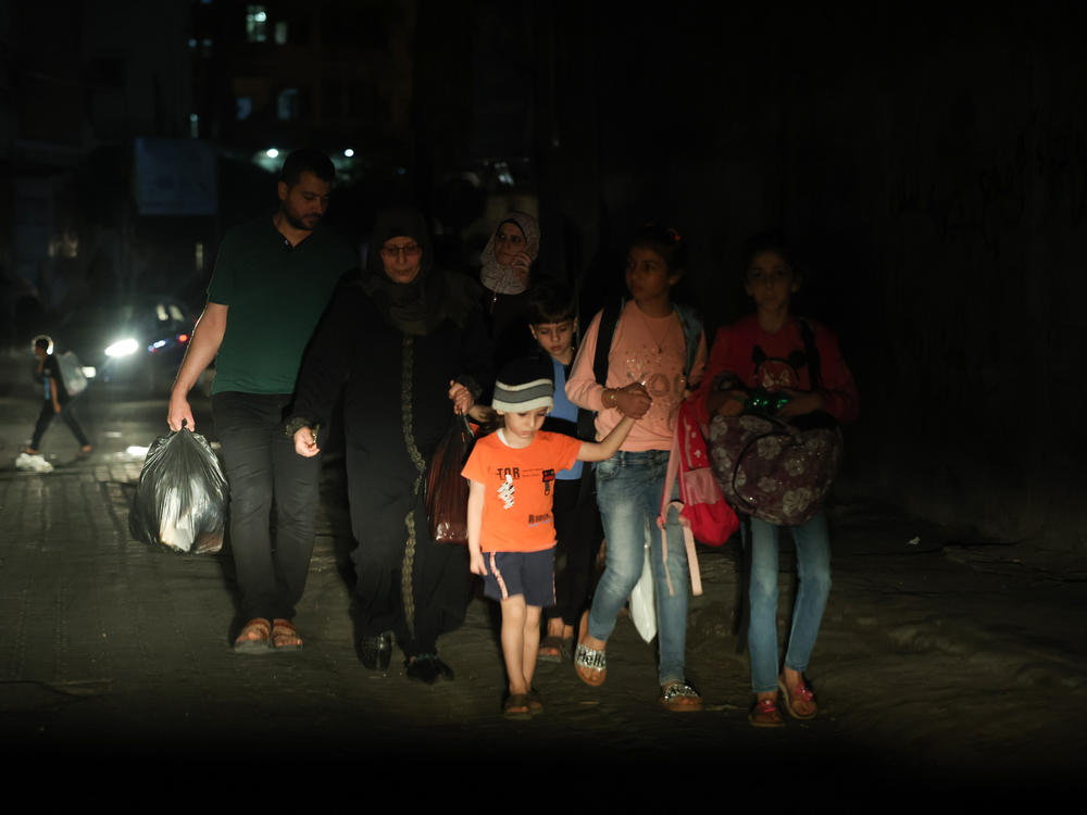 A Palestinian family evacuates their home in the middle of the night during the Israeli bombardment of Gaza.