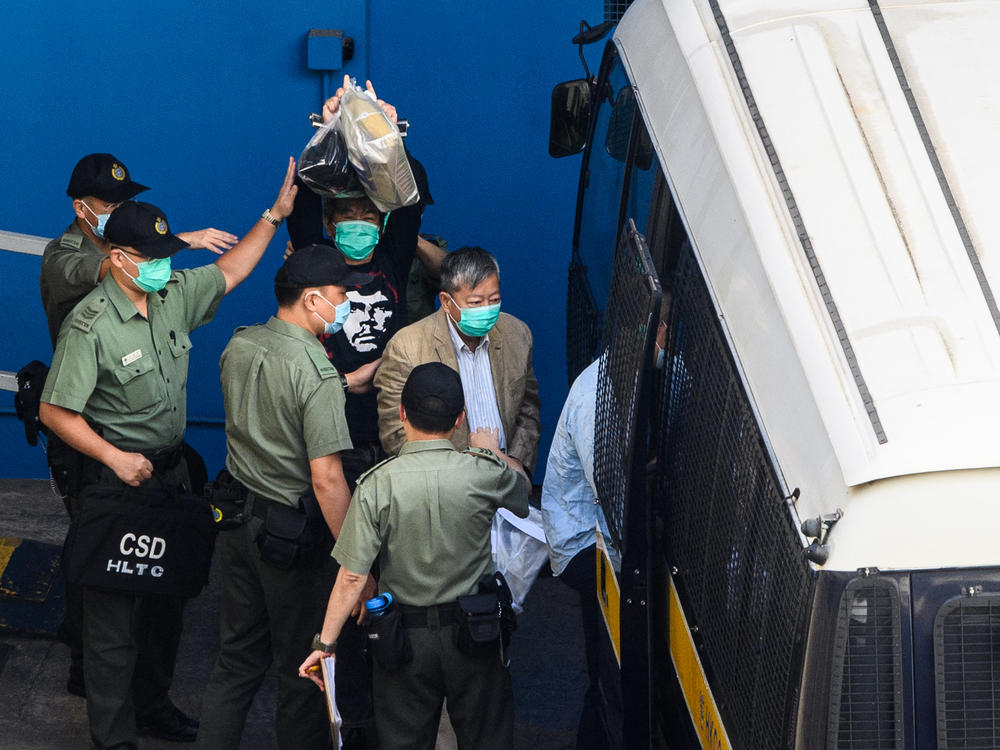 Pro-democracy activists Leung Kwok-hung (center) and Lee Cheuk-yan head to a Hong Kong Correctional Services van Friday before their sentencing hearing. Both received three years in prison for organizing and attending a protest on China's National Day on Oct. 1, 2019.