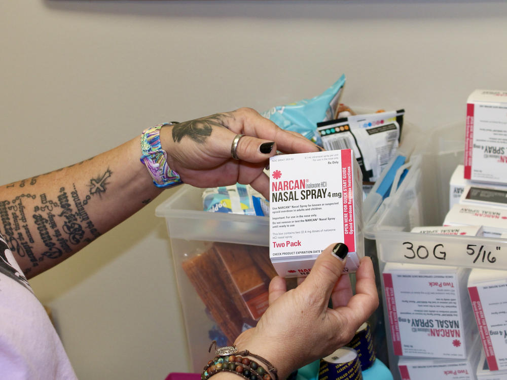 Kelly Hans holds a box of Narcan nasal spray at the county's One-Stop Shop in Austin.