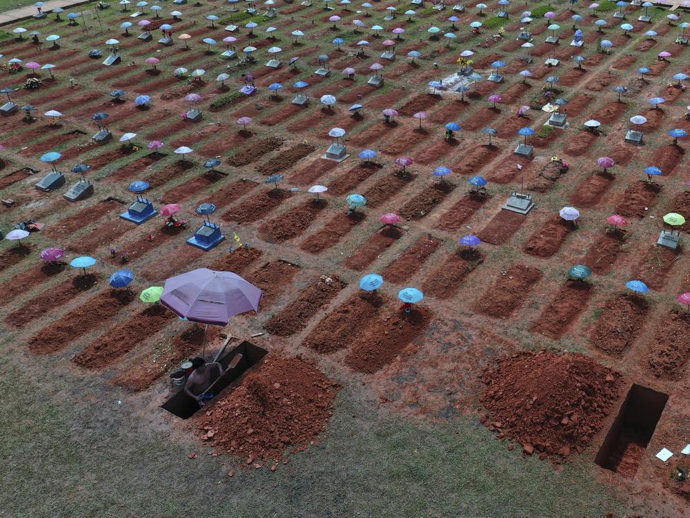 A worker digs a grave in the San Juan Bautista cemetery in Iquitos, Peru, amid the coronavirus pandemic. On May 31, 2021, Peru announced a sharp increase in its COVID-19 death toll, saying there have been more than 180,000 fatalities since the pandemic hit the country early last year.