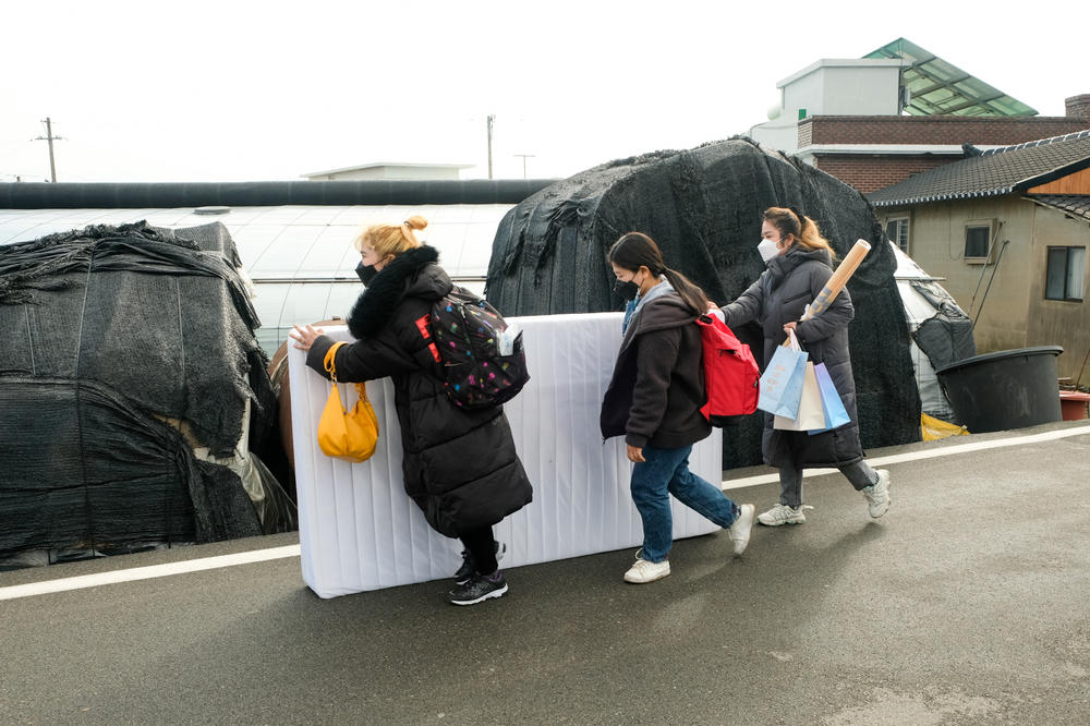 Labor rights activists help a Cambodian migrant farm worker move her belongings out of her dwelling in Miryang, South Korea. The activists help the migrants, who complain of poor treatment, find new jobs.