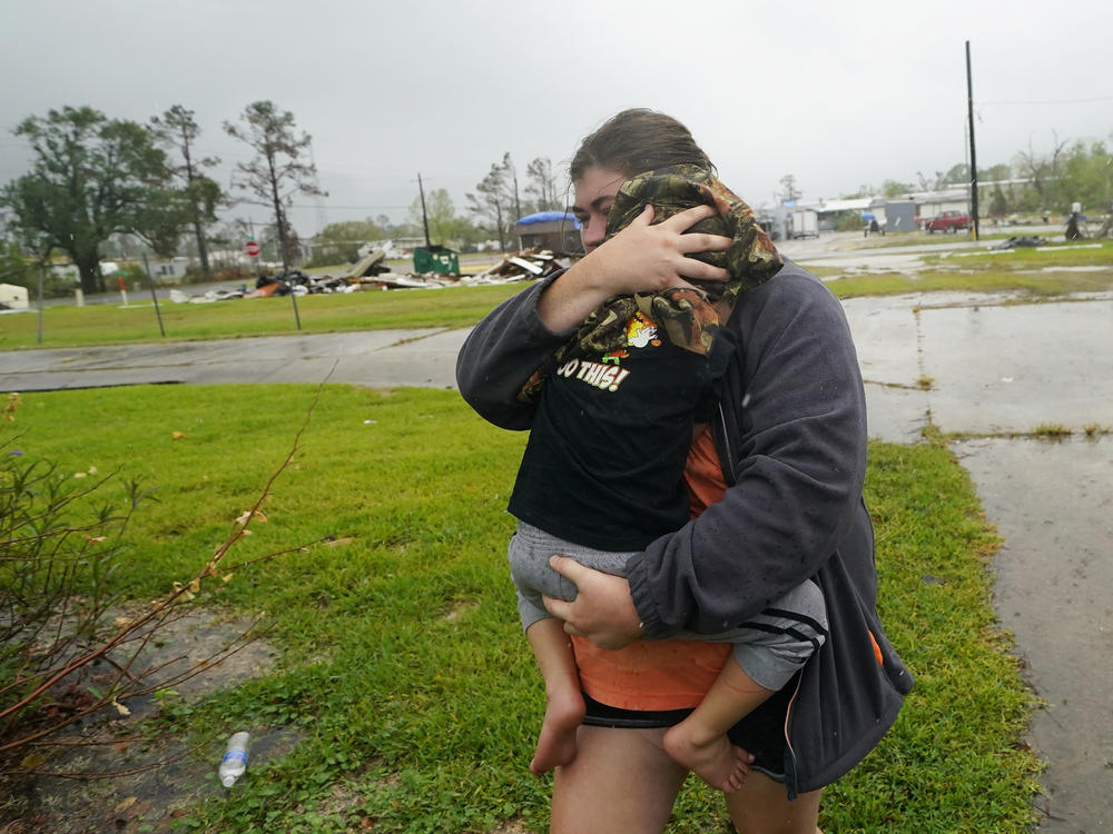 Danielle Fontenot runs to a relative's home in the rain with her son, Hunter, ahead of Hurricane Delta in Lake Charles, La., last October. The 2021 Atlantic hurricane season began June 1.