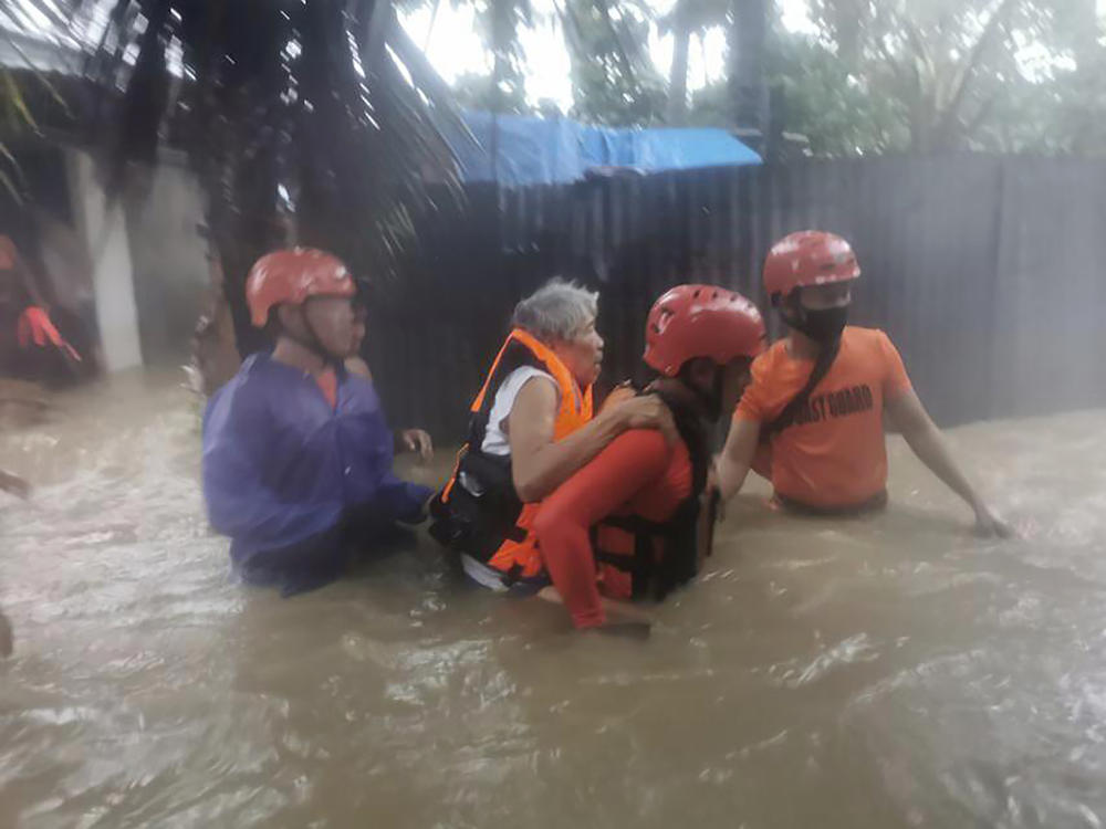 Rescuers take residents to safer ground as floods caused by Tropical Storm Dante hit Maasin City in Southern Leyte province, central Philippines. The tropical storm has left at least a few people dead and displaced hundreds of people in the southern and central Philippines.