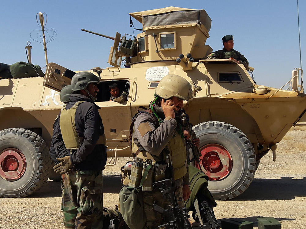 Afghan security forces stand near an armored vehicle during ongoing fighting with the Taliban in the Busharan area on the outskirts of Lashkar Gah, the capital city of Helmand province, on May 5.