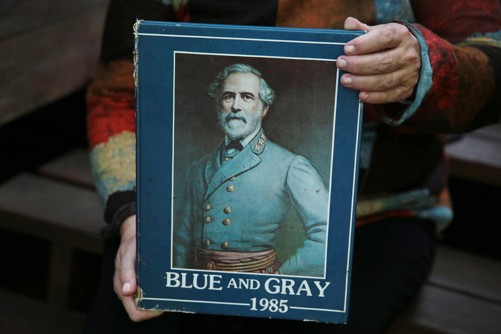Julie Moore holds her 1985 yearbook with a portrait of Robert E. Lee on the cover. She supports changing the school name.