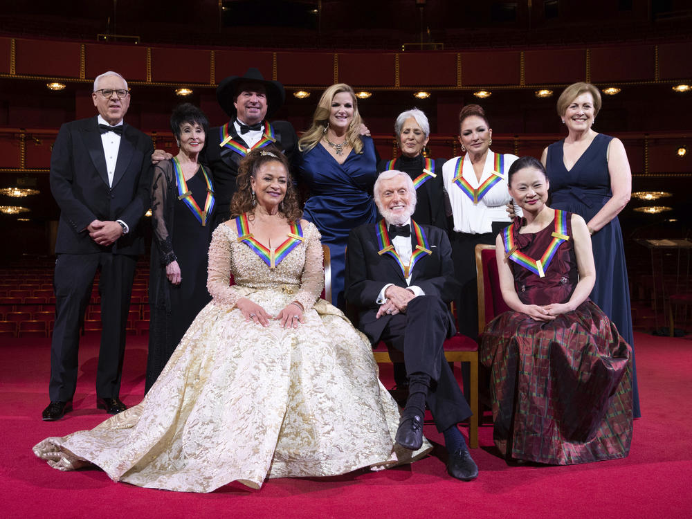 David Rubenstein, Chita Rivera, Garth Brooks, Debbie Allen, Trisha Yearwood, Dick Van Dyke, Joan Baez, Gloria Estefan, Midori, and Kennedy Center president Deborah F. Rutter pose for a group photo at the 43nd annual Kennedy Center Honors.