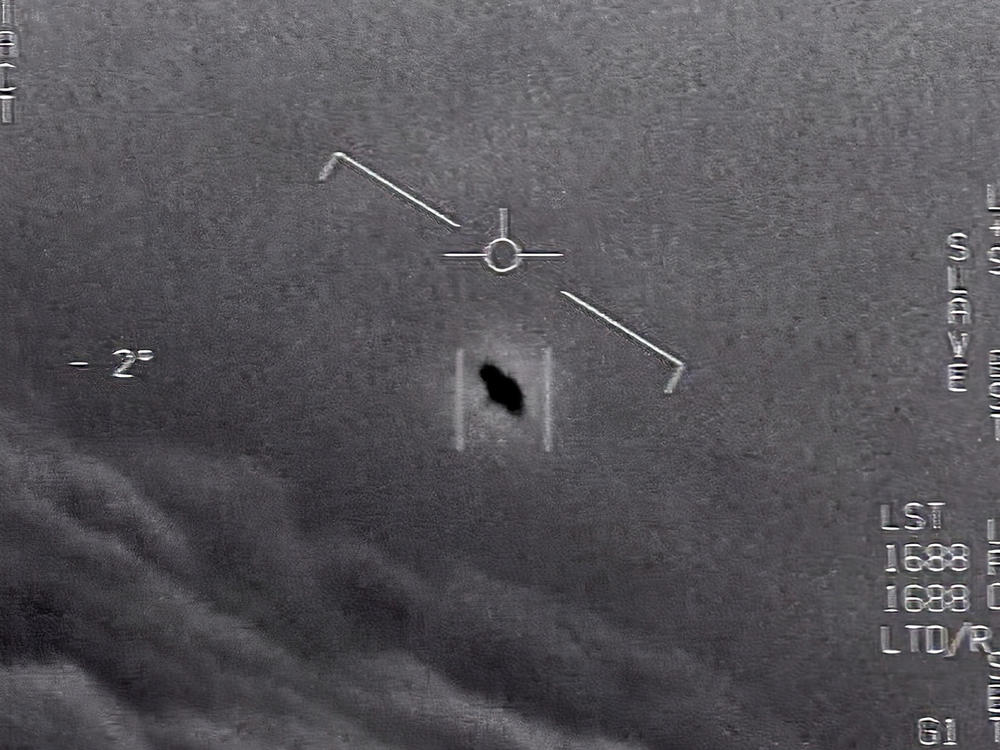 In an image from video footage from 2015, an unexplained object is seen at center as it soars among the clouds, traveling against the wind. 