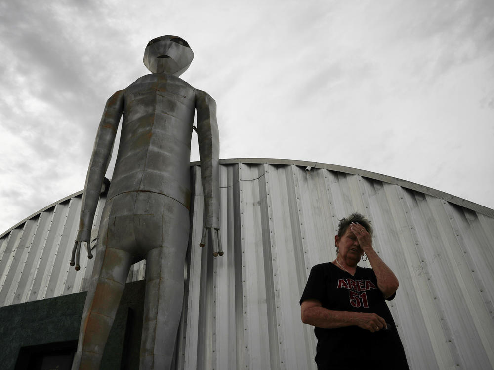 Linda Looney wipes her face outside the Alien Research Center, a gift shop on the Extraterrestrial Highway, in Crystal Springs, Nev., in 2019. The tiny desert town is near Area 51, a secret government facility some believe is a research center devoted to studies of space aliens.