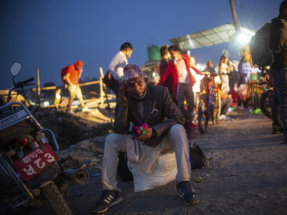Villagers wait to board a bus to head home in the wake of government-imposed restrictions relating to COVID-19 in Kathmandu valley.