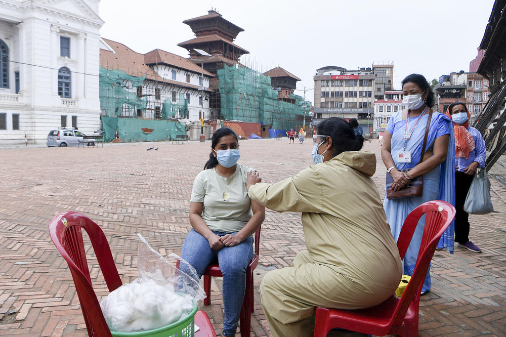 A health worker inoculates a woman in Kathmandu with a Chinese-made vaccine.