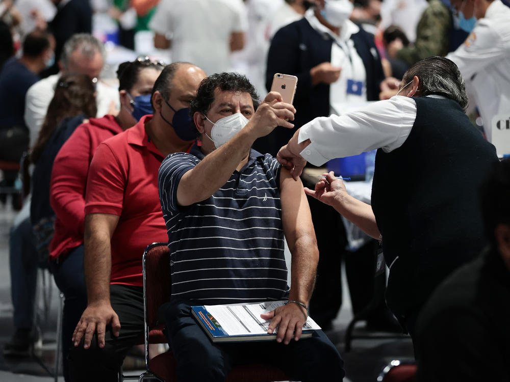 A man takes a selfie while getting the COVID-19 vaccine during a vaccination day in Mexico City.