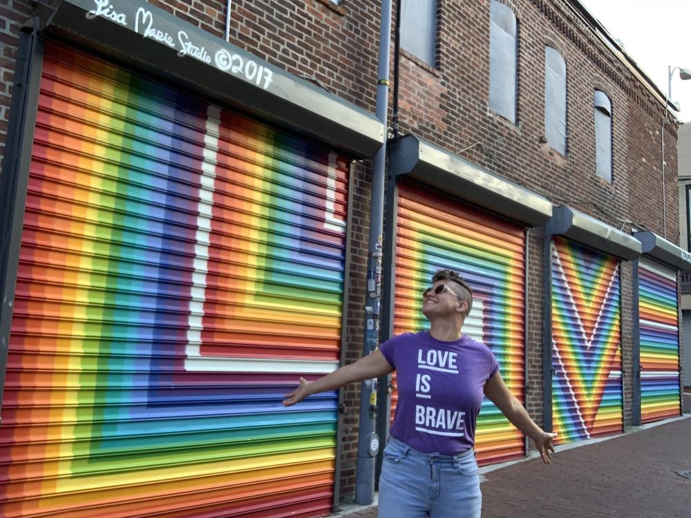 Lisa Marie Thalhammer poses last summer in front of her 2017 <em>LOVE</em> mural in D.C.'s Blagden Alley.