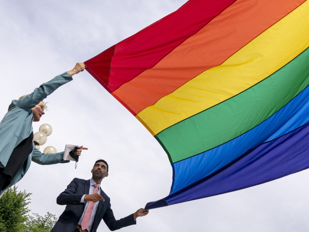 Energy Secretary Jennifer Granholm and Department of Energy Chief of Staff Tarak Shah help raise the Progress Pride Flag outside the DOE in Washington on Wednesday. The Pentagon decided not to allow the flag to fly on military installations for Pride Month.