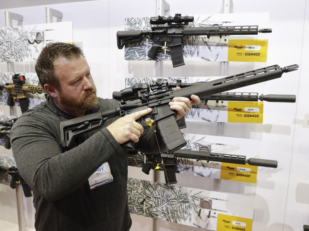 Bryan Oberc, in Munster, Ind., tries out an AR-15 from Sig Sauer in the exhibition hall at the National Rifle Association Annual Meeting in Indianapolis in 2019.