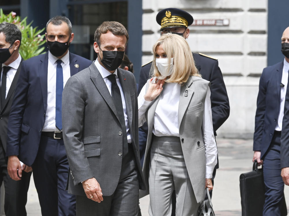 French President Emmanuel Macron and his wife, Brigitte, arrive for a lunch Tuesday in Valence, France. A man slapped the president in the face during the French leader's visit to a small town in southern France.