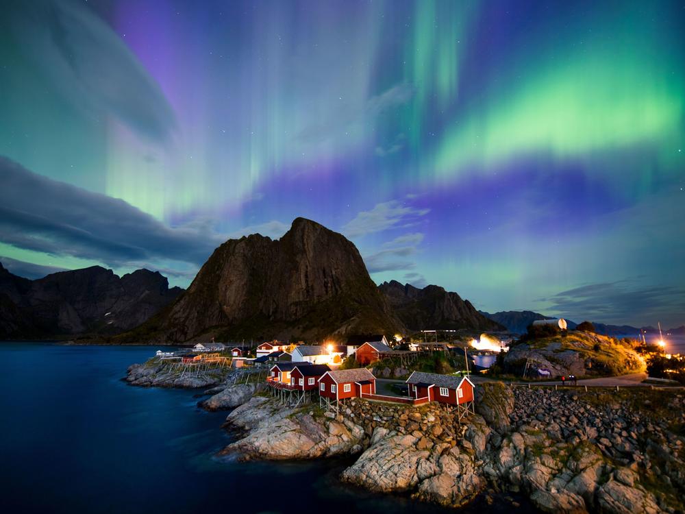 The northern lights (aurora borealis) illuminate the sky over Reinfjorden in Reine, on Lofoten Islands in the Arctic Circle in 2017.