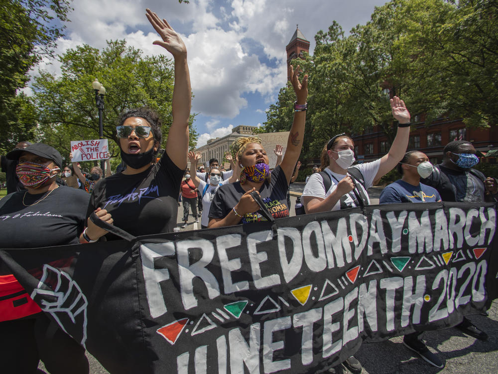 People observe a moment of silence at the Martin Luther King Jr. Memorial in Washington on Friday, June 19, 2020, to mark Juneteenth. (AP Photo/Manuel Balce Ceneta)