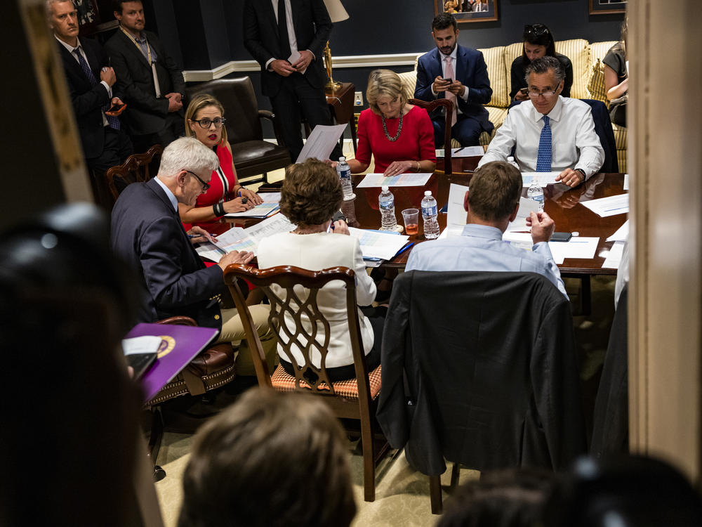 From left: Sens. Bill Cassidy, R-La., Kyrsten Sinema, D-Ariz., Lisa Murkowski, R-Alaska, Mitt Romney, R-Utah, and others hold a bipartisan meeting on infrastructure in the basement of the U.S. Capitol on Tuesday.