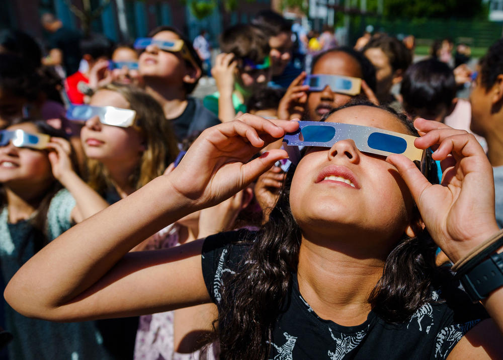 Pupils, wearing protective glasses, look at the partial solar eclipse in Schiedam, Netherlands, on Thursday.