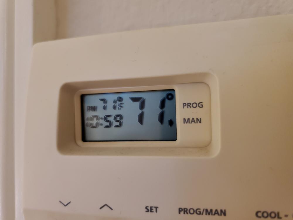A wall-mounted thermostat in a California home. New research finds households that can least afford it are spending more than they have to on electricity.