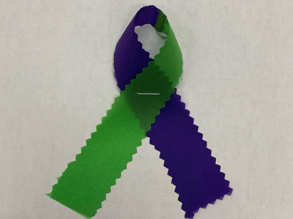 Attendants of a vigil in memory of Salman, Madiha, Yumna and Talat wore green and purple ribbons.