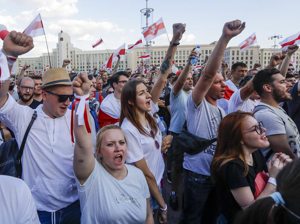 People with old Belarusian national flags shout during an opposition rally in August in Minsk, Belarus.
